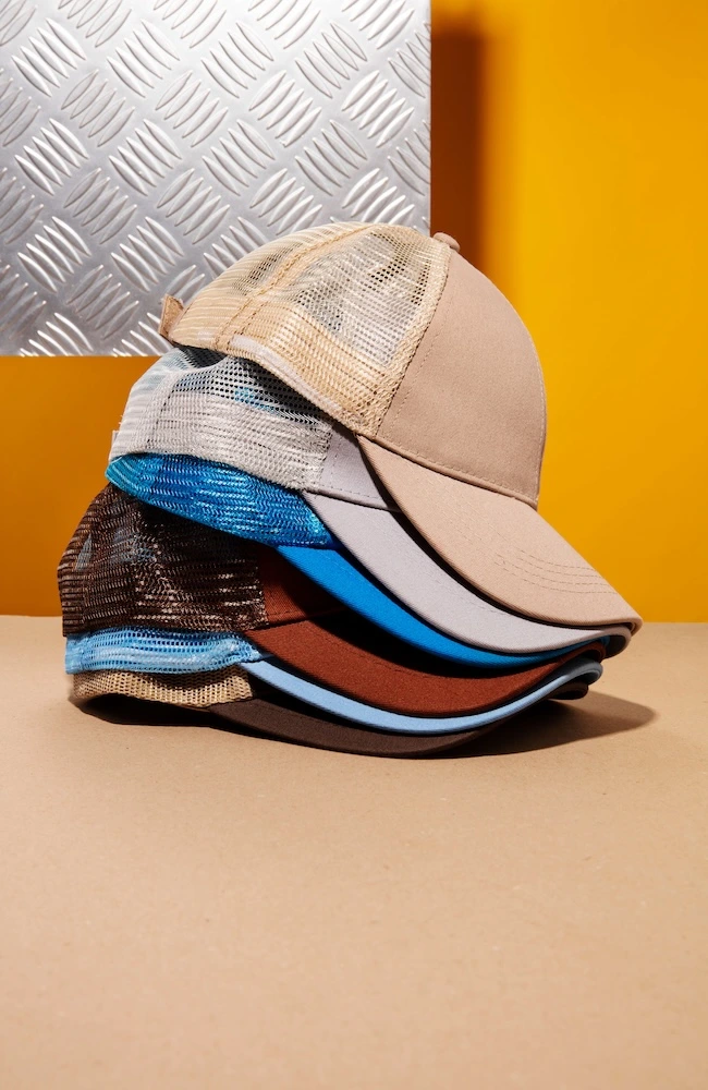 Stack of mesh trucker caps in colours beige, stone, brown and blue